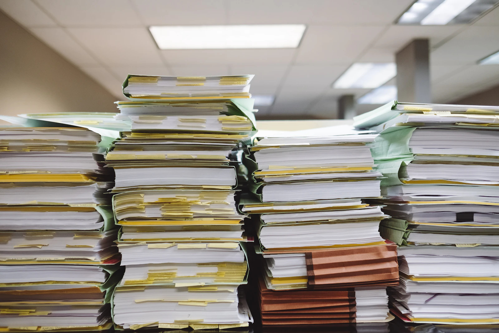 Stacks of paper applications and folders in an office